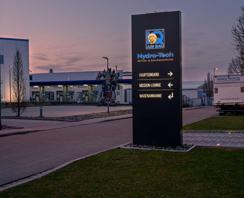 Gerader Werbepylon Nacht Gerader Werbepylon mit Leuchtlogo und Leuchtbuchstaben